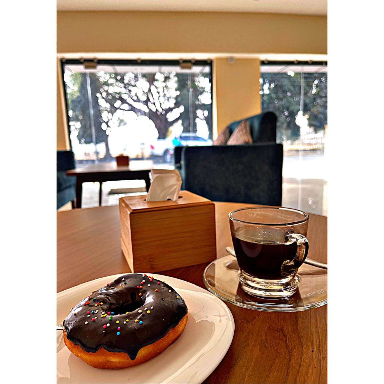 Chocolate donut and americano by the window
