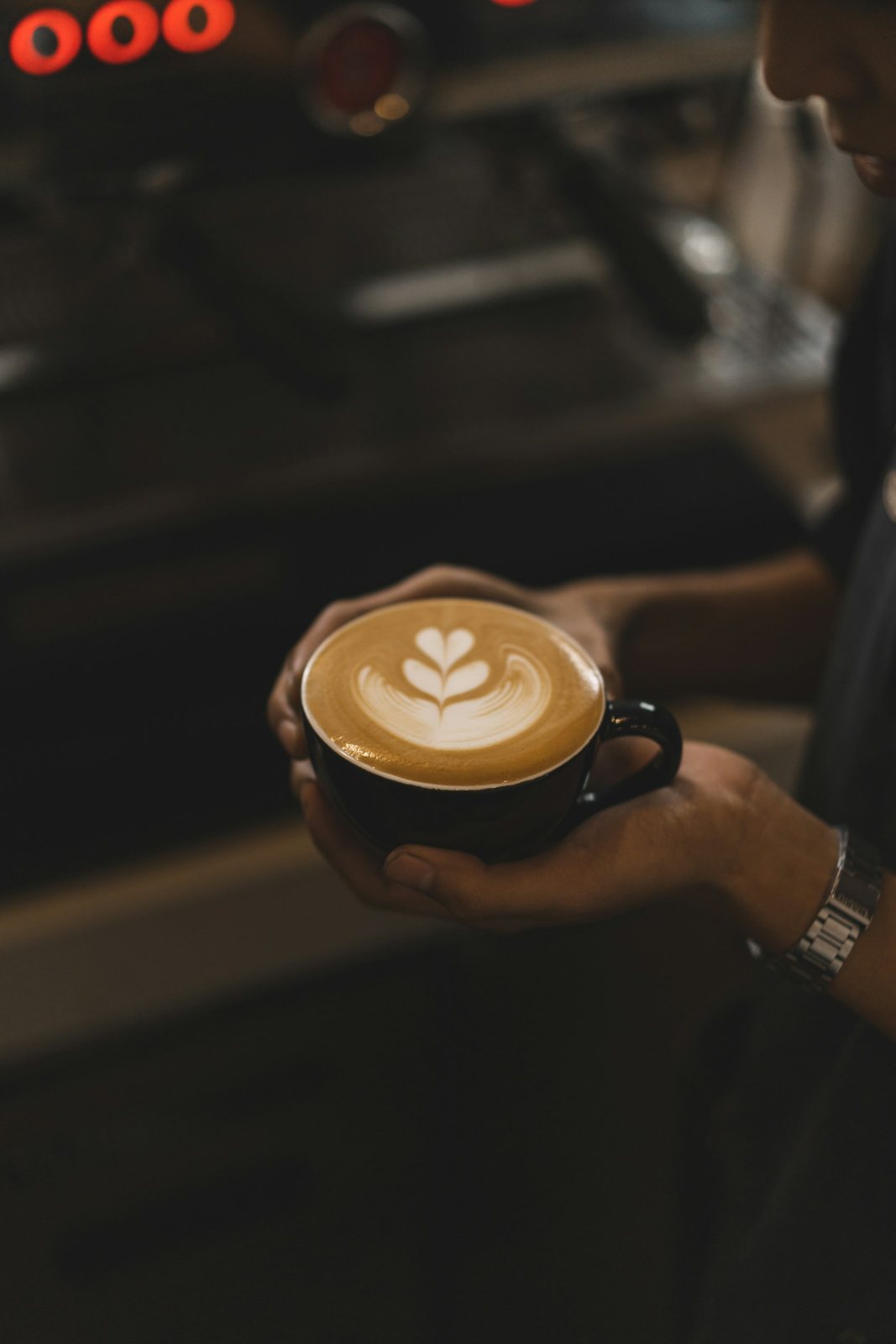 Cappuccino with latte art held in two hands